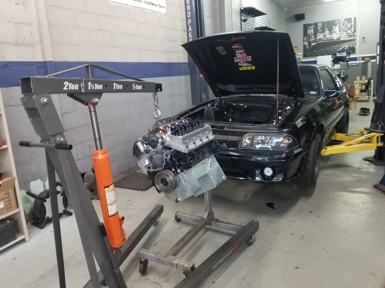 Engine on crane going into car Engine on crane going into car